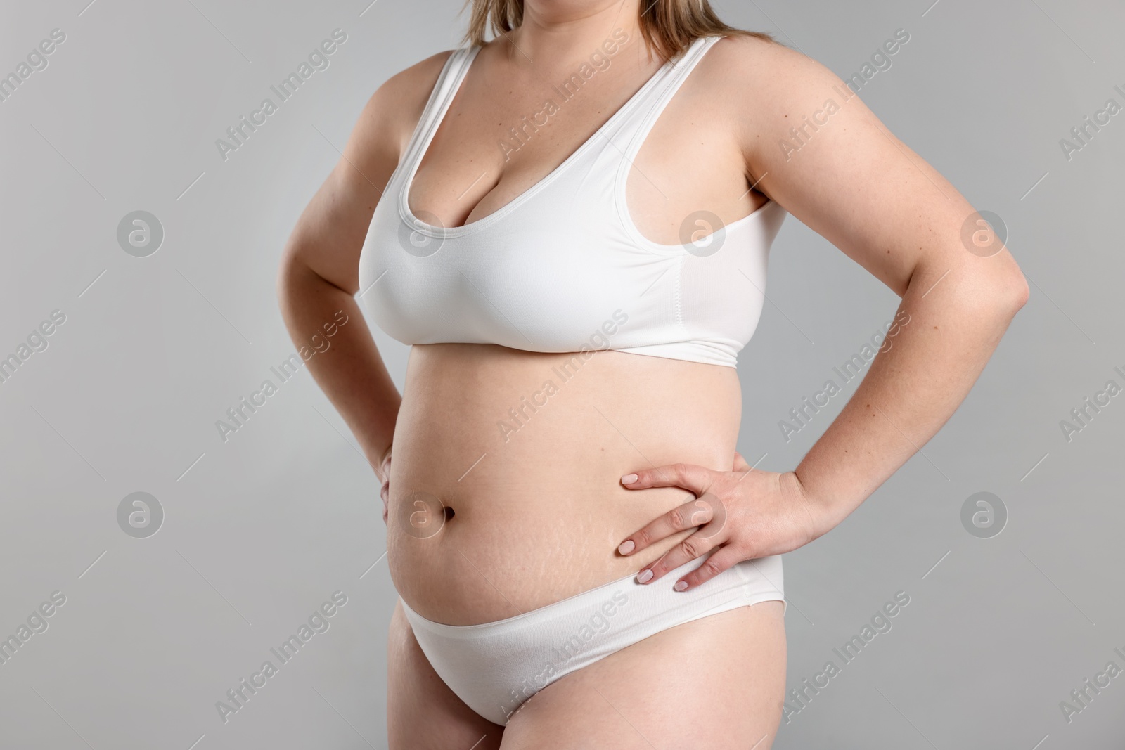 Weight loss. Plus size woman in underwear on gray background, closeup Photo of Weight loss. Plus size woman in underwear on gray background, closeup