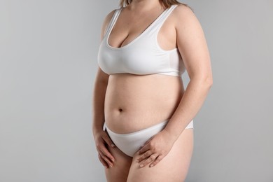 Photo of Weight loss. Plus size woman in underwear on gray background, closeup