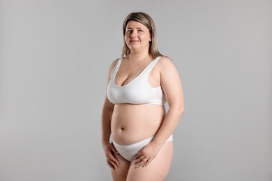 Photo of Weight loss. Plus size woman in underwear on gray background