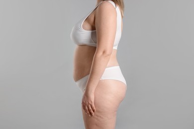 Photo of Weight loss. Plus size woman in underwear on gray background, closeup