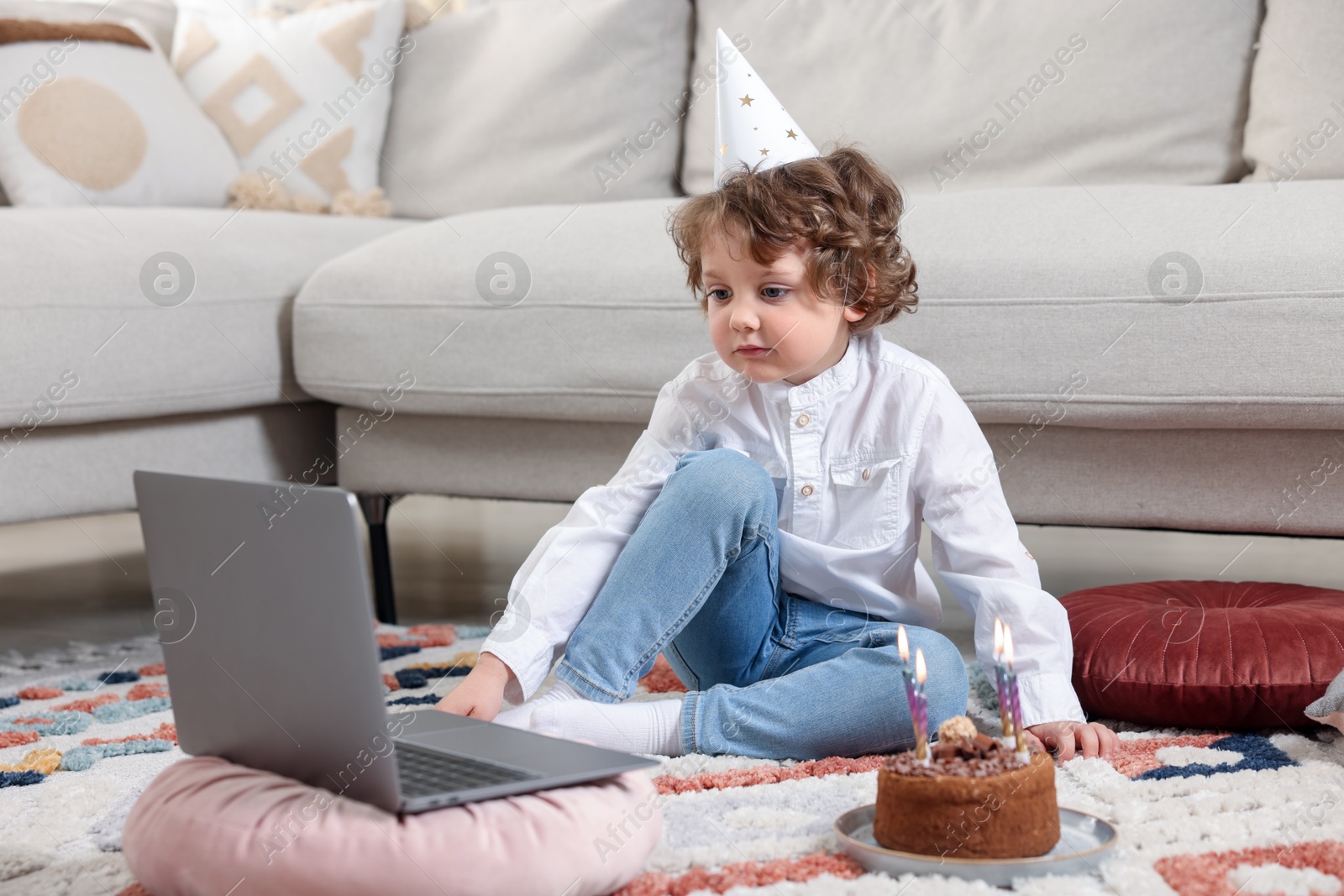 Birthday celebration. Little boy with cake having video call via laptop at home Photo of Birthday celebration. Little boy with cake having video call via laptop at home