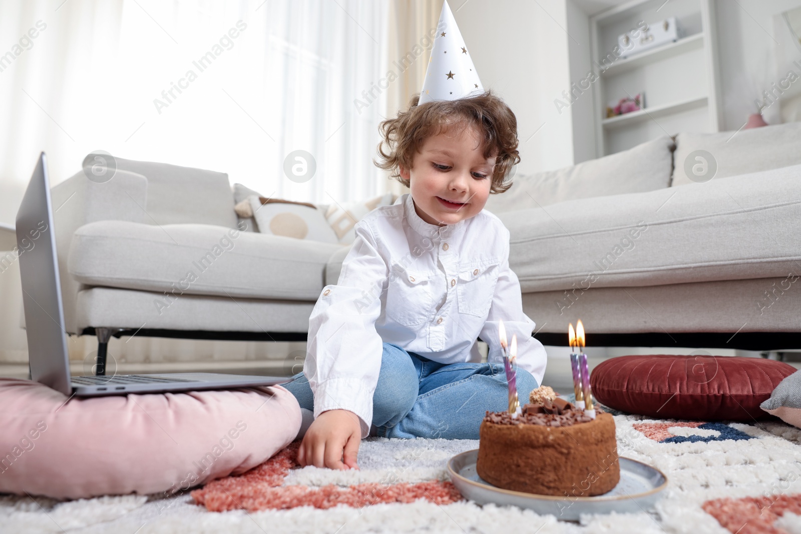 Birthday celebration. Little boy with cake having video call via laptop at home Photo of Birthday celebration. Little boy with cake having video call via laptop at home