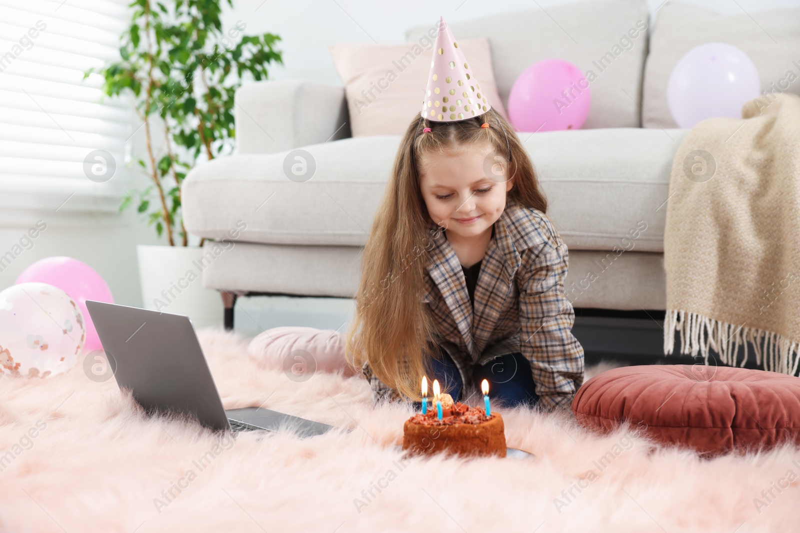 Birthday celebration. Little girl with cake having video call via laptop at home Photo of Birthday celebration. Little girl with cake having video call via laptop at home