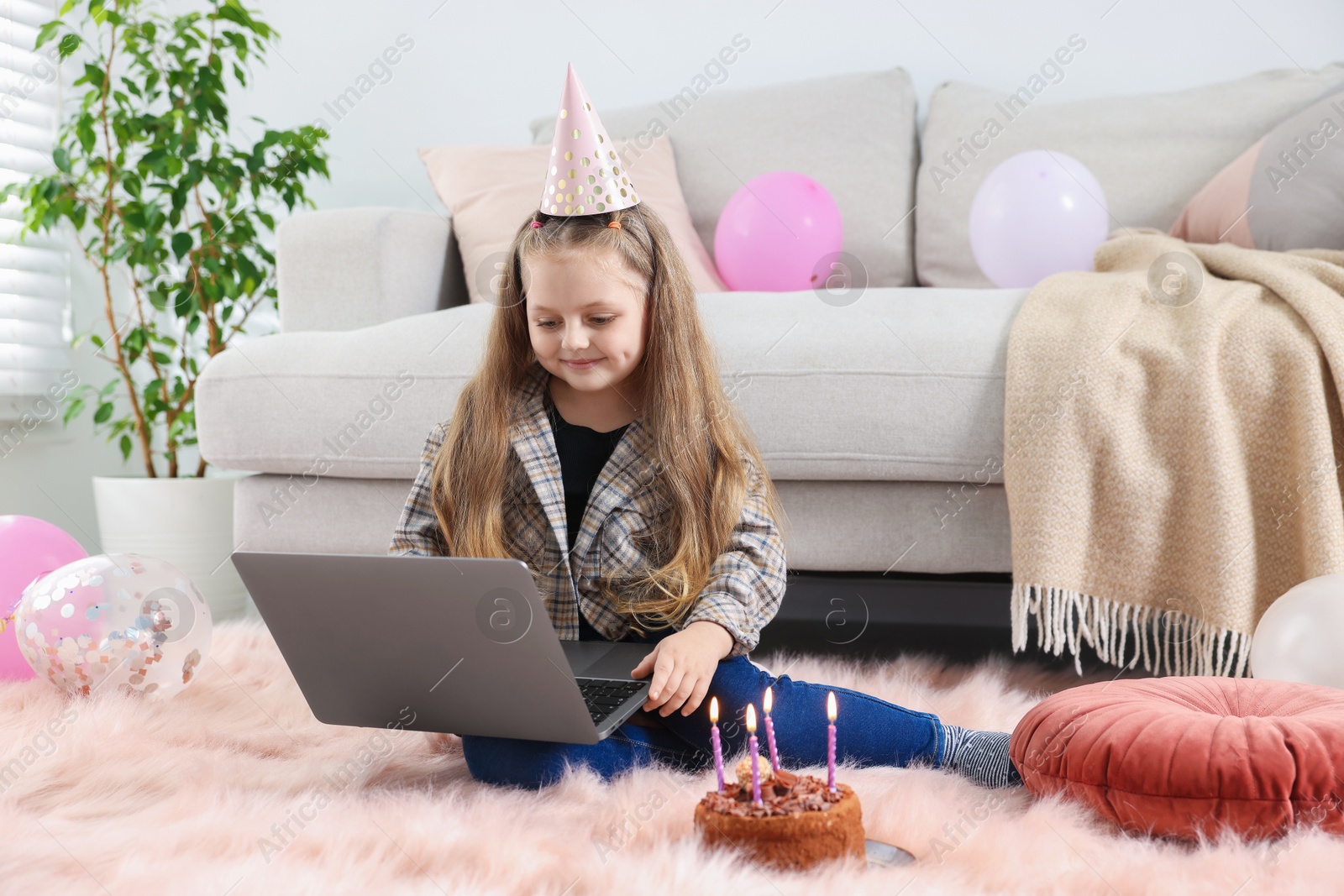 Birthday celebration. Little girl with cake having video call via laptop at home Photo of Birthday celebration. Little girl with cake having video call via laptop at home