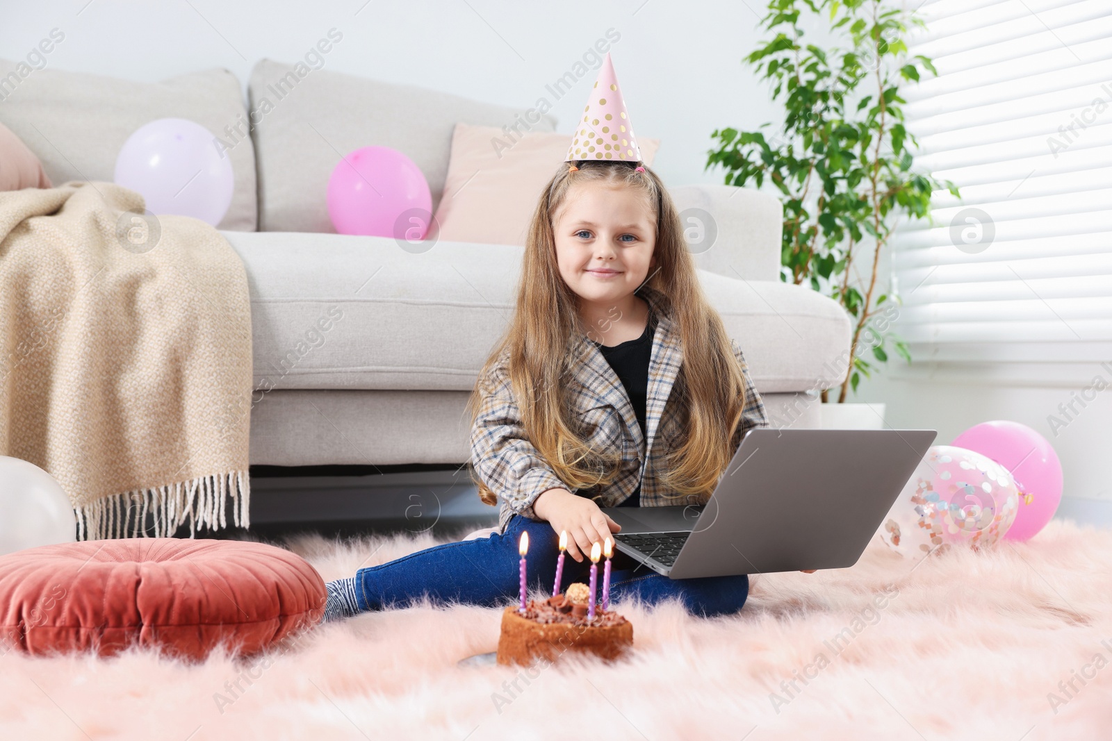 Birthday celebration. Little girl with cake having video call via laptop at home Photo of Birthday celebration. Little girl with cake having video call via laptop at home