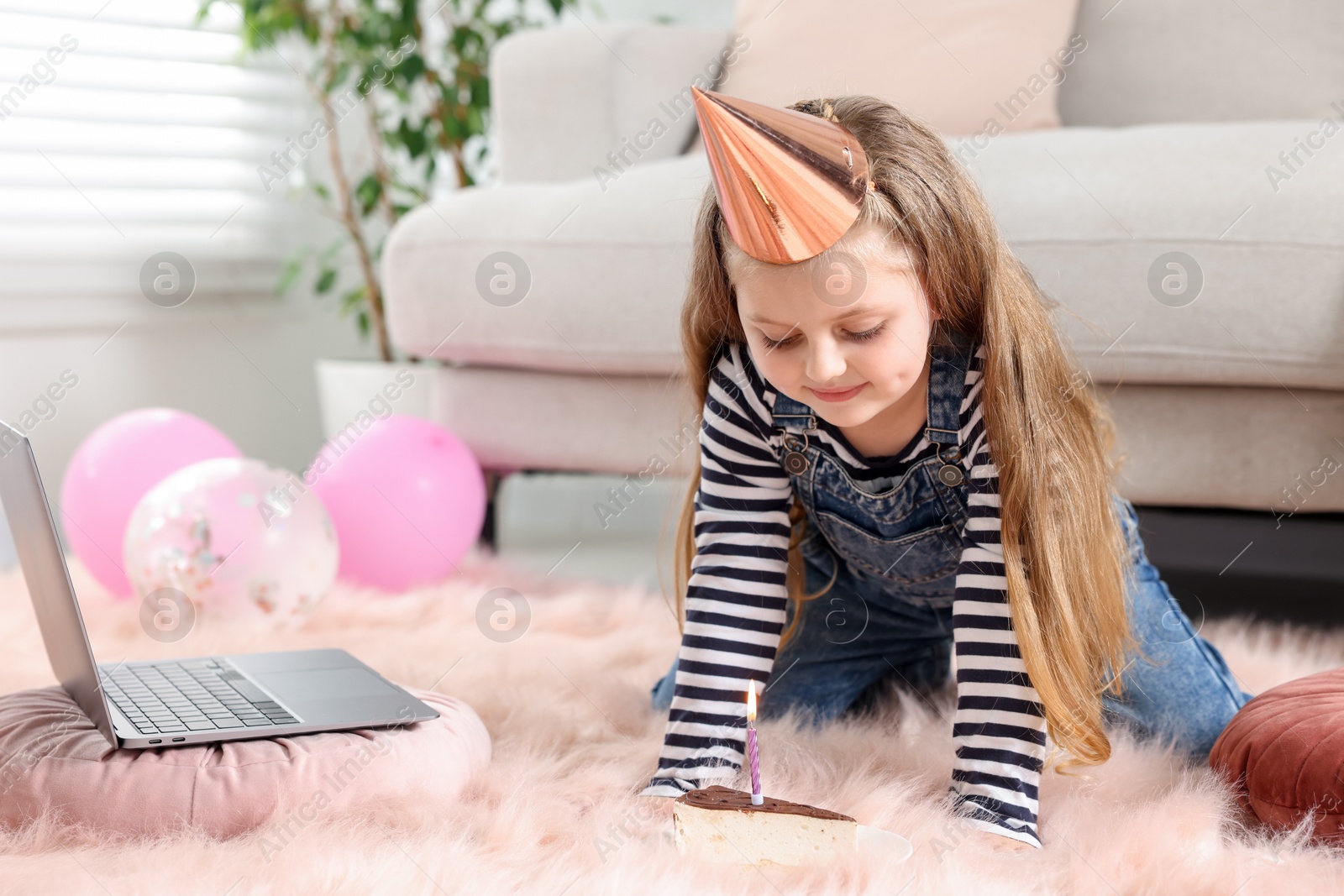 Birthday celebration. Little girl with piece of cake having video call via laptop at home Photo of Birthday celebration. Little girl with piece of cake having video call via laptop at home