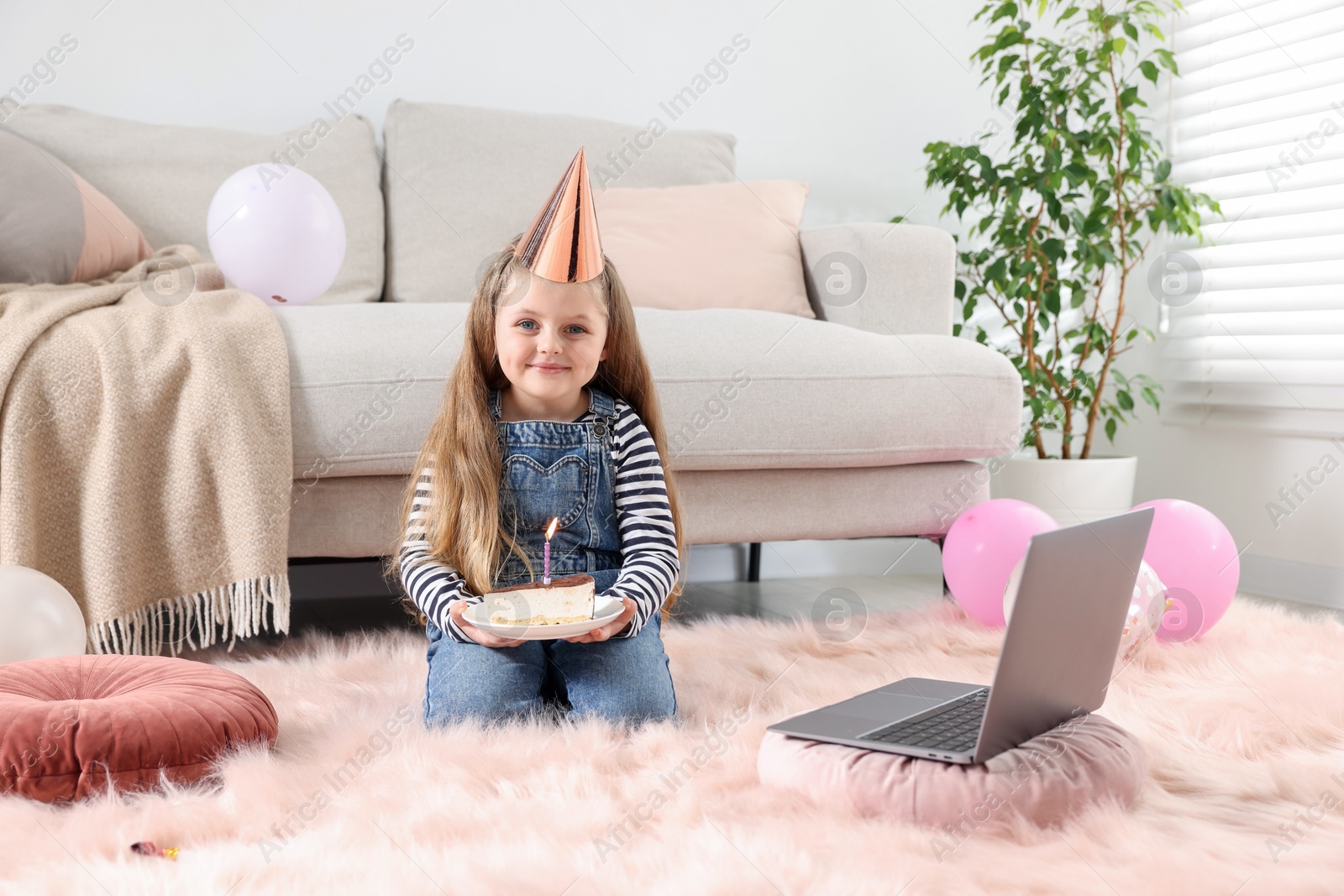 Birthday celebration. Little girl with piece of cake having video call via laptop at home Photo of Birthday celebration. Little girl with piece of cake having video call via laptop at home