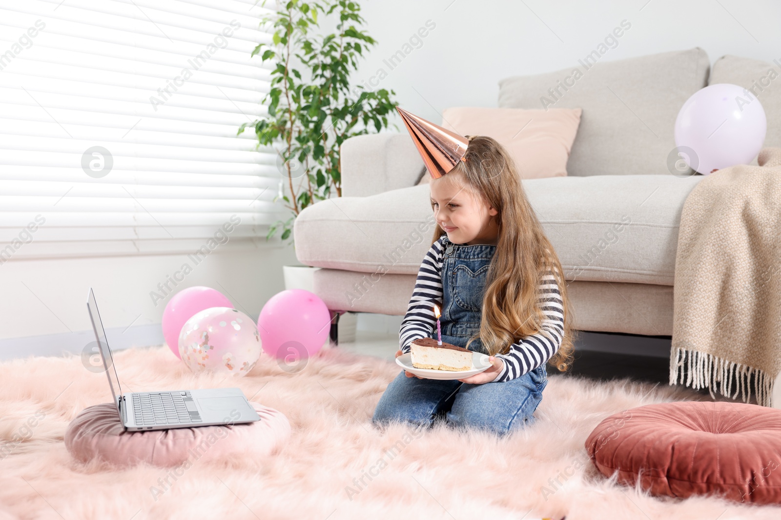 Birthday celebration. Little girl with piece of cake having video call via laptop at home Photo of Birthday celebration. Little girl with piece of cake having video call via laptop at home