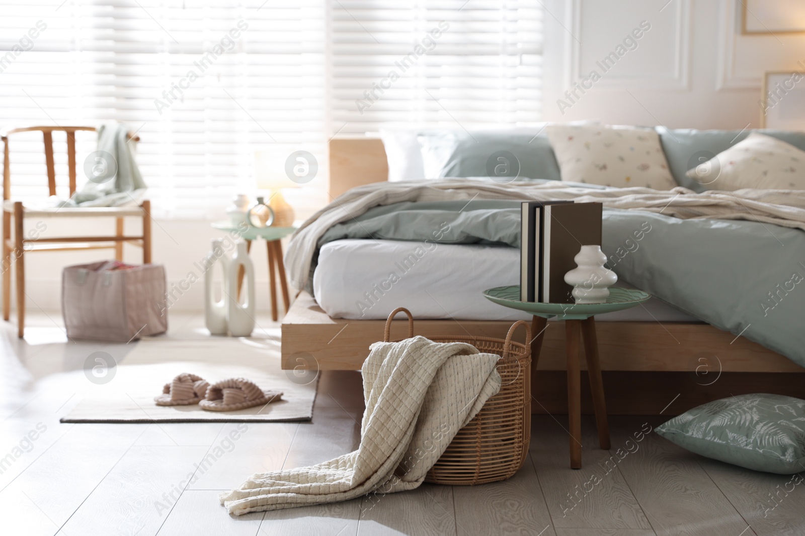 Comfortable bed with soft linens and decor in stylish room. Home textile Photo of Comfortable bed with soft linens and decor in stylish room. Home textile