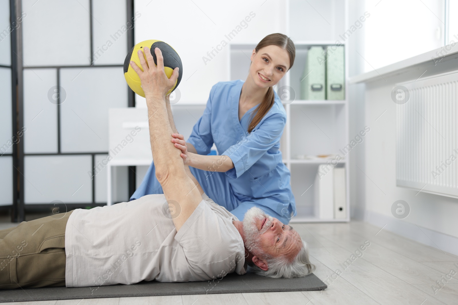 Doctor and patient exercising with medicine ball in clinic Photo of Doctor and patient exercising with medicine ball in clinic