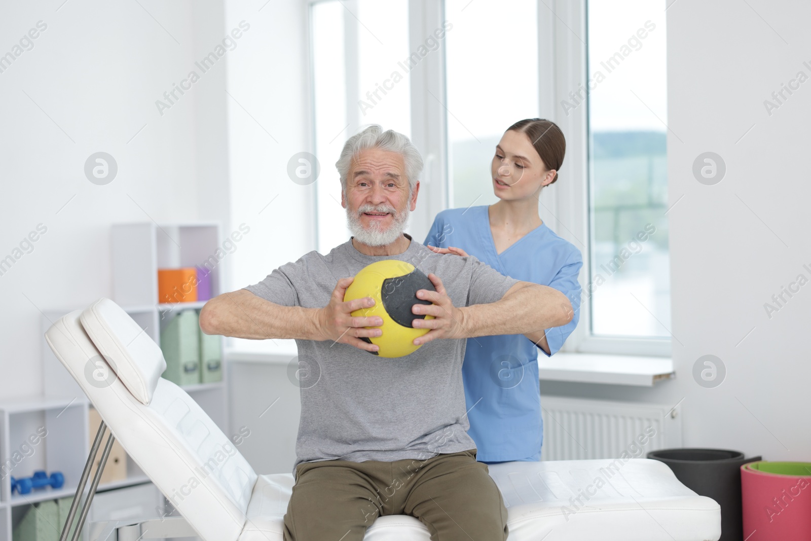 Doctor and patient exercising with medicine ball in clinic Photo of Doctor and patient exercising with medicine ball in clinic