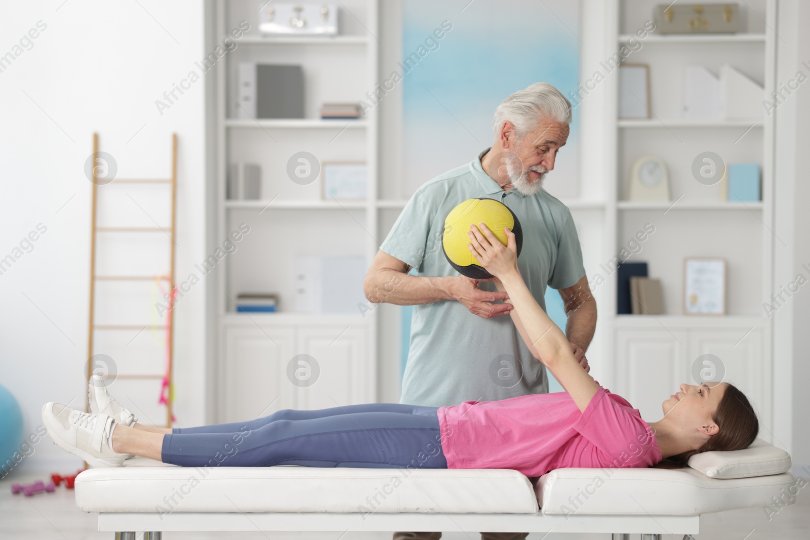 Doctor and patient exercising with medicine ball in clinic Photo of Doctor and patient exercising with medicine ball in clinic