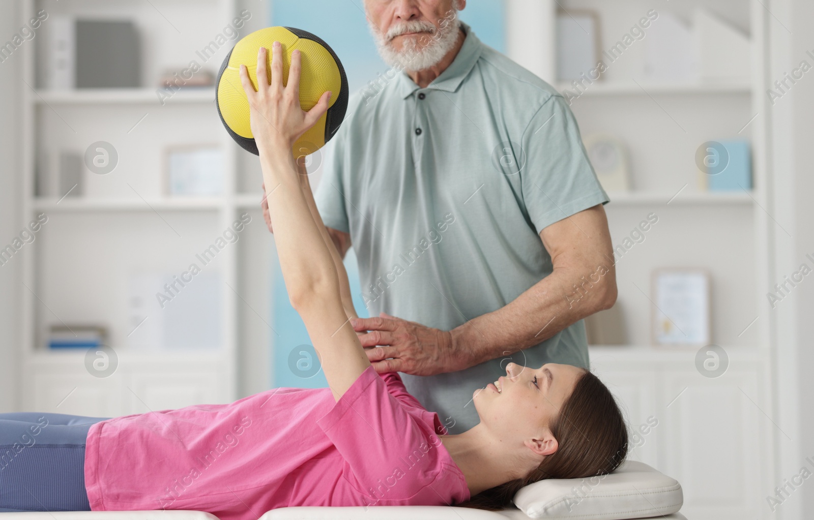 Doctor and patient exercising with medicine ball in clinic Photo of Doctor and patient exercising with medicine ball in clinic