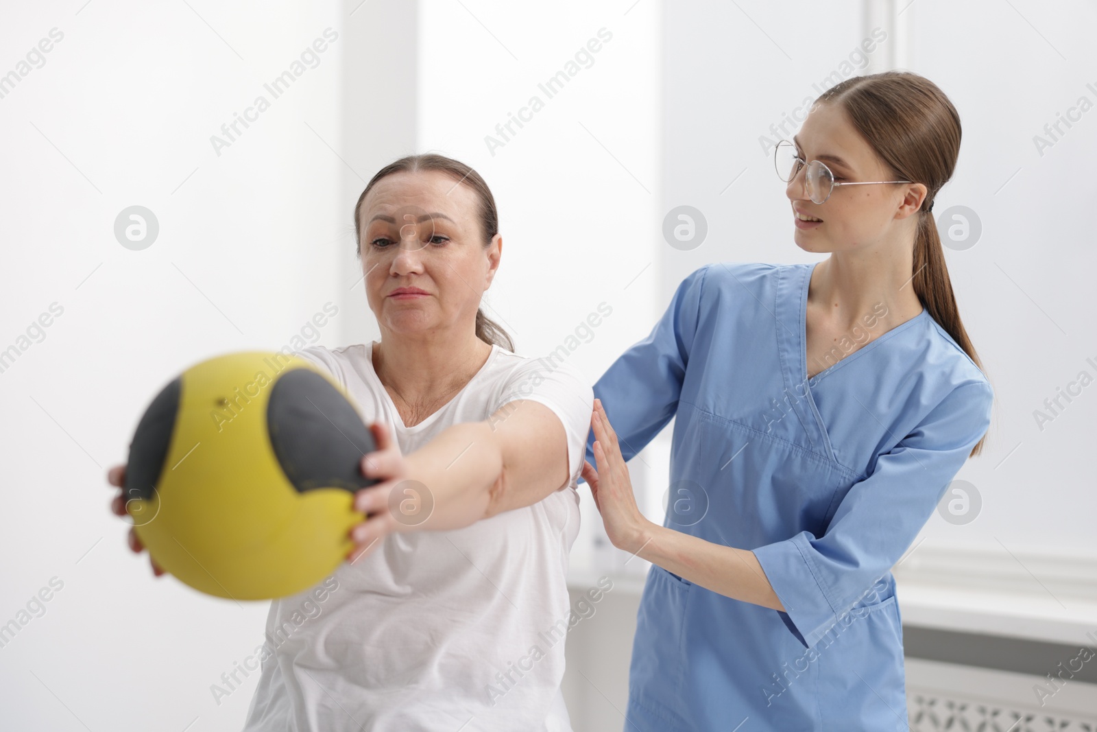 Doctor and patient exercising with medicine ball in clinic Photo of Doctor and patient exercising with medicine ball in clinic