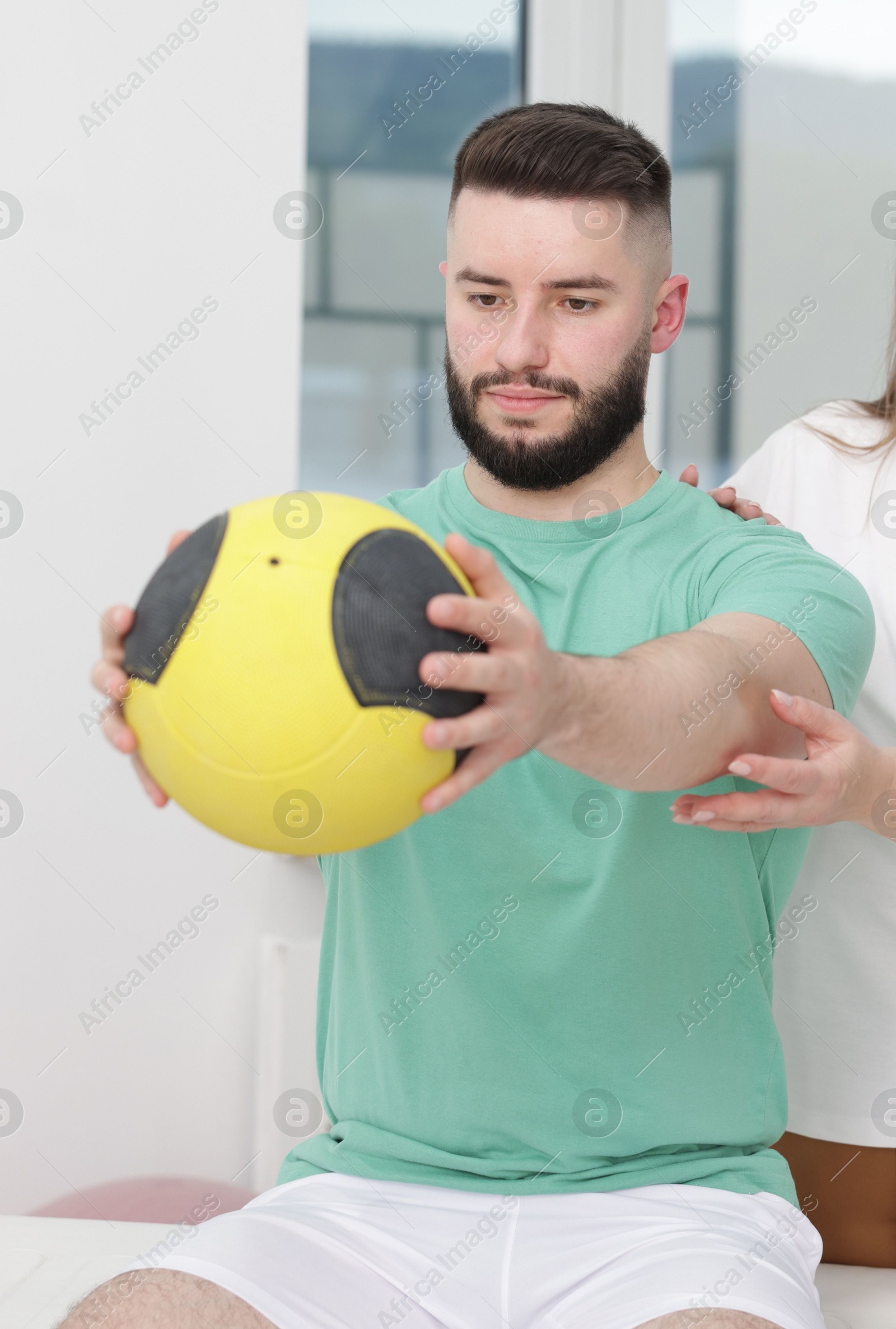 Doctor and patient exercising with medicine ball in clinic Photo of Doctor and patient exercising with medicine ball in clinic