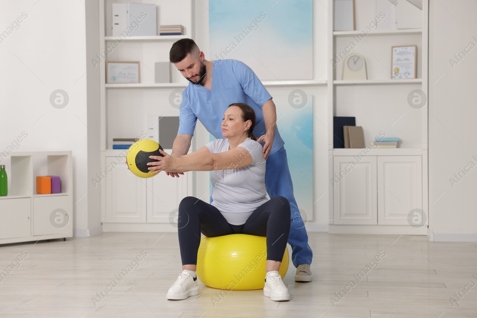 Doctor and patient exercising with medicine ball in clinic Photo of Doctor and patient exercising with medicine ball in clinic