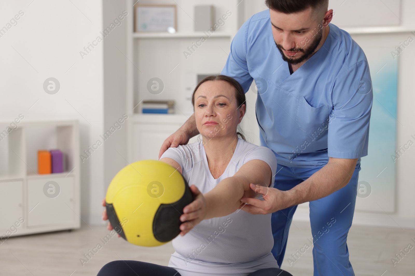 Doctor and patient exercising with medicine ball in clinic Photo of Doctor and patient exercising with medicine ball in clinic