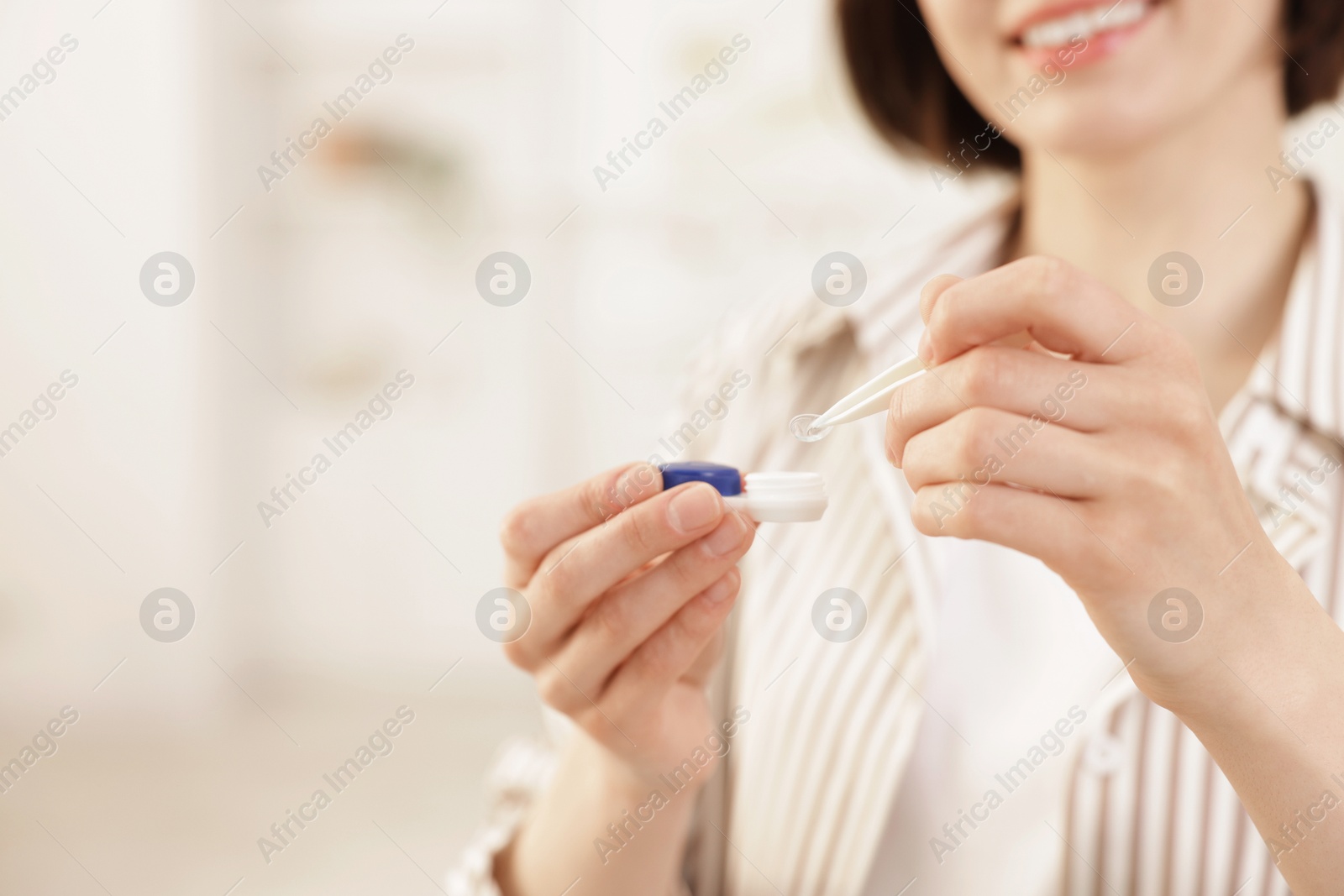 Woman taking contact lens out of case indoors, closeup. Space for text Photo of Woman taking contact lens out of case indoors, closeup. Space for text
