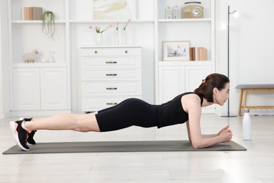 Photo of Woman doing plank exercise at home. Sport and healthy lifestyle
