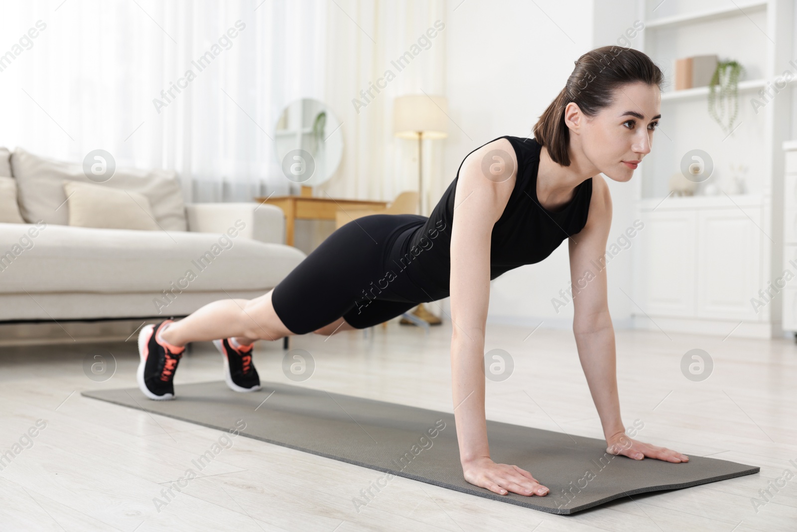 Woman doing plank exercise at home. Sport and healthy lifestyle Photo of Woman doing plank exercise at home. Sport and healthy lifestyle