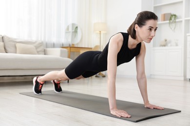 Photo of Woman doing plank exercise at home. Sport and healthy lifestyle
