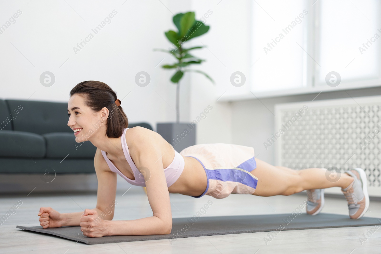 Woman doing plank exercise at home. Sport and healthy lifestyle Photo of Woman doing plank exercise at home. Sport and healthy lifestyle