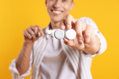 Photo of Man with glasses and contact lenses on yellow background, selective focus