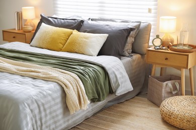 Photo of Comfortable bed with soft linens and blankets in room. Home textile