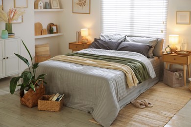 Photo of Comfortable bed with soft linens and blankets in room. Home textile