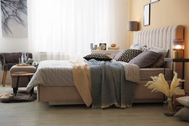 Photo of Comfortable bed with soft linens and blankets in room. Home textile