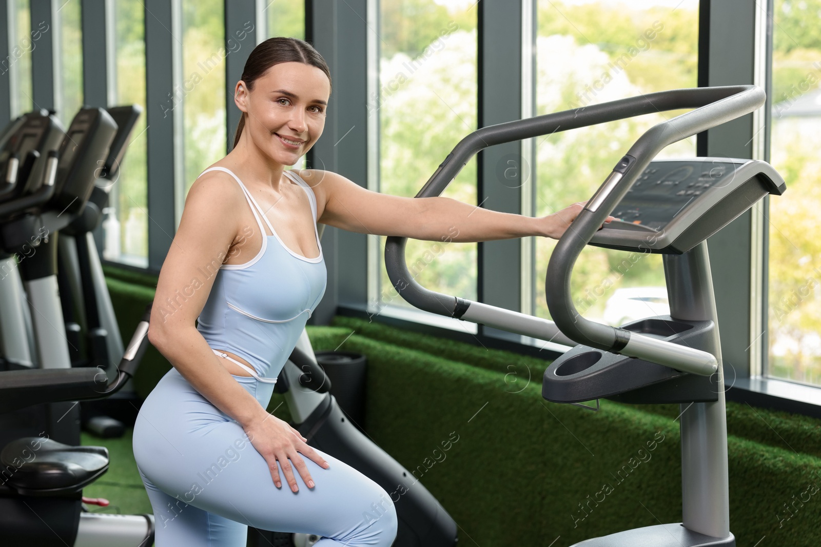 Personal coach using elliptical trainer in sport center Photo of Personal coach using elliptical trainer in sport center
