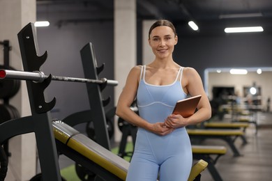 Photo of Professional personal trainer with tablet in gym