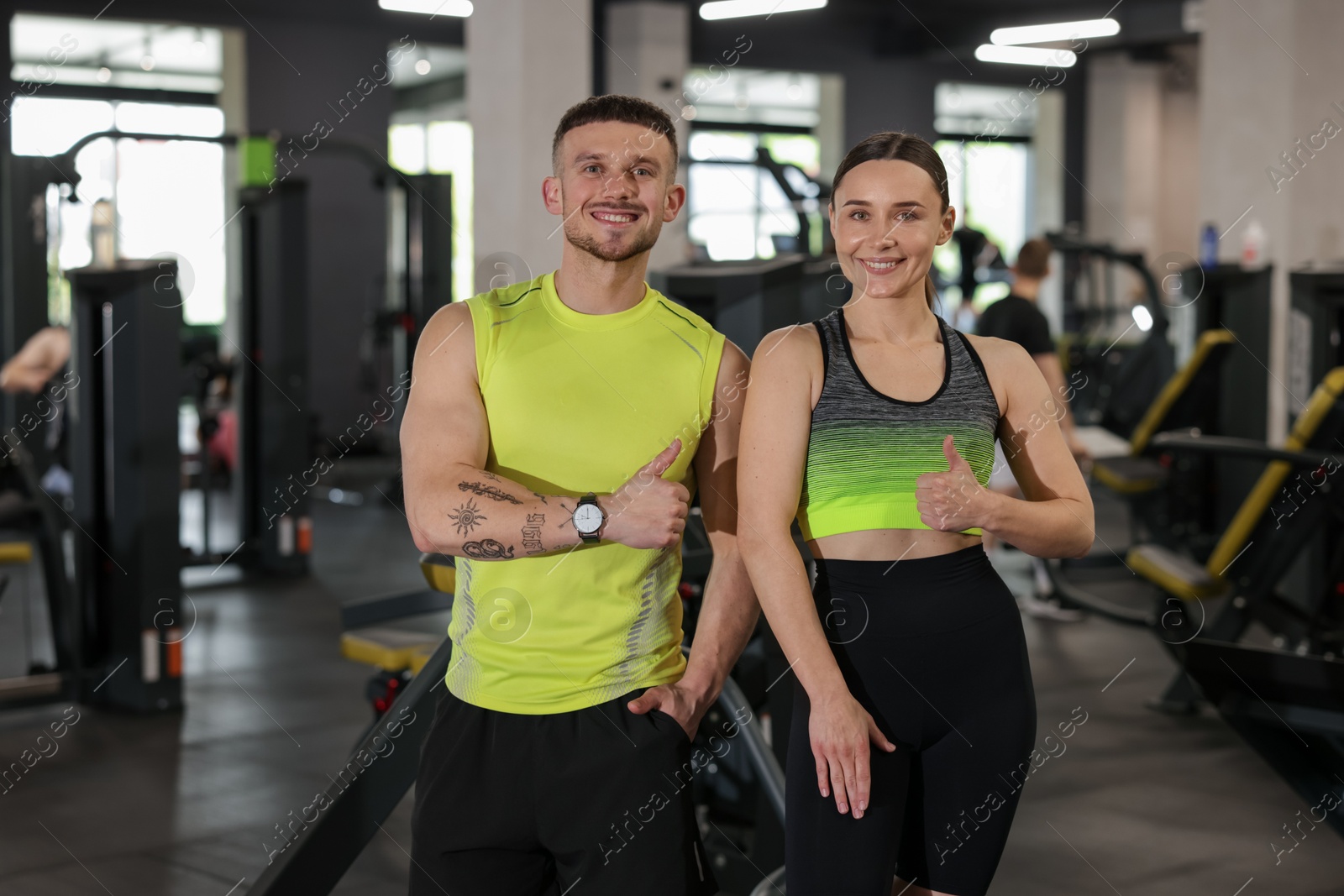 Personal trainers showing thumbs ups in gym Photo of Personal trainers showing thumbs ups in gym