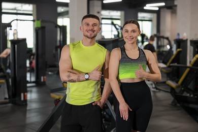 Photo of Personal trainers showing thumbs ups in gym