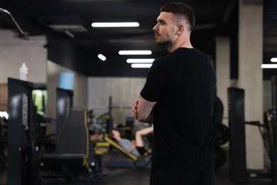 Photo of Professional personal trainer in sport center. Space for text
