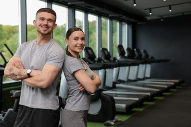 Photo of Portrait of personal trainers in sport center. Space for text