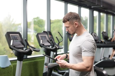 Photo of Professional personal trainer with clipboard in gym