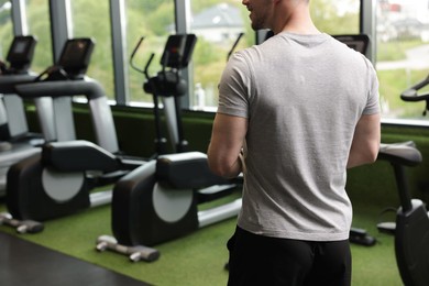 Photo of Personal trainer in sport center, back view