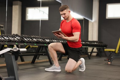 Photo of Personal trainer with tablet in sport center