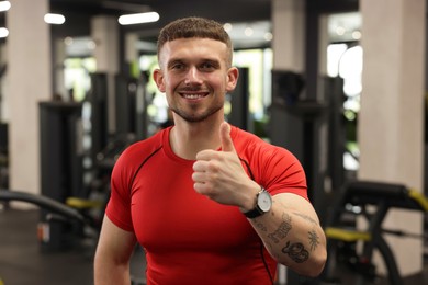 Photo of Personal trainer showing thumbs up in gym