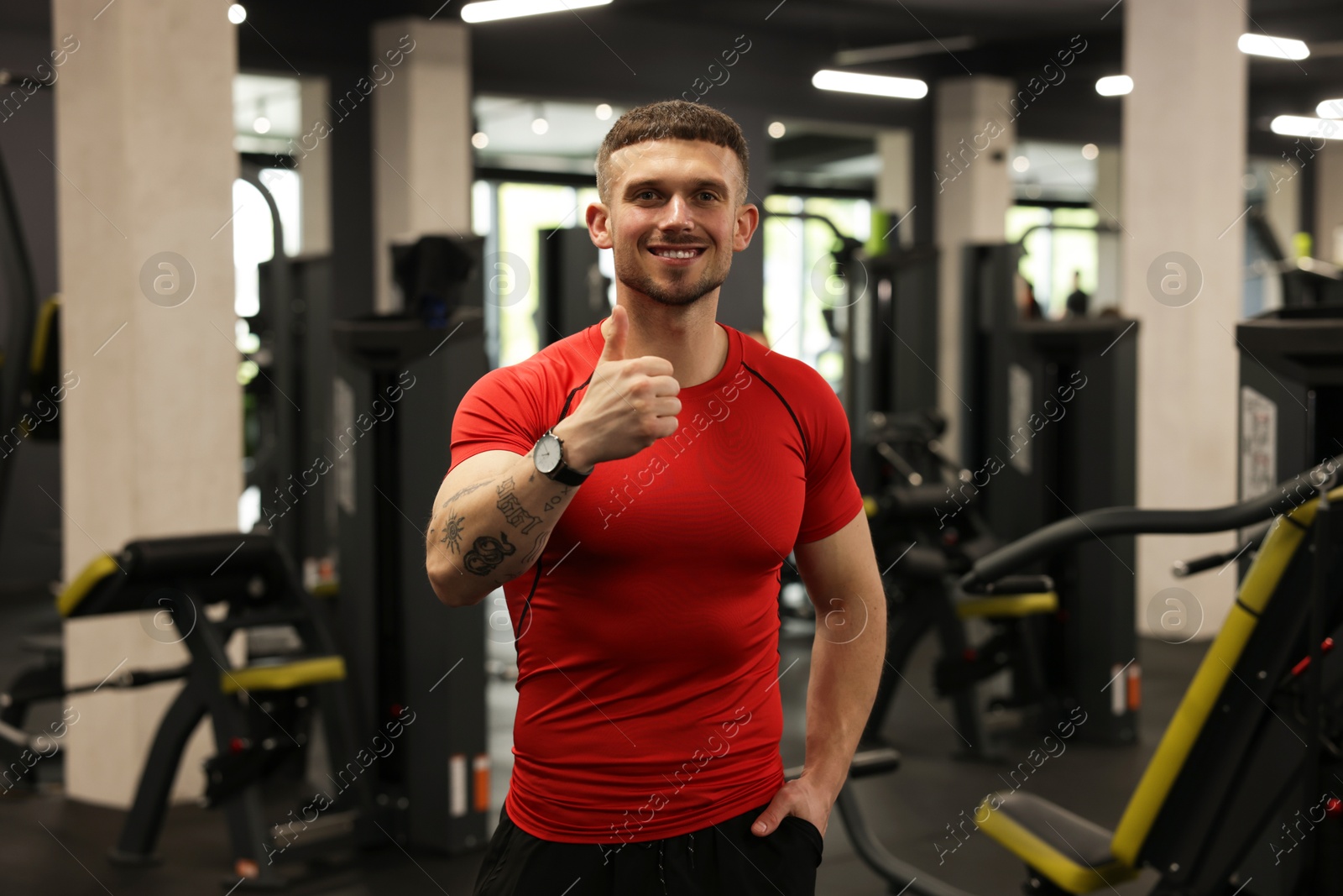 Personal trainer showing thumbs up in gym Photo of Personal trainer showing thumbs up in gym