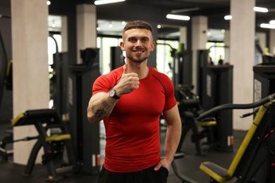 Photo of Personal trainer showing thumbs up in gym