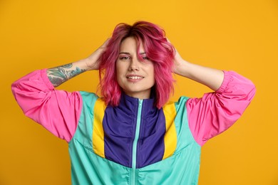 Photo of Beautiful woman with pink dyed hair on yellow background