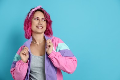 Photo of Beautiful woman with pink dyed hair on light blue background, space for text