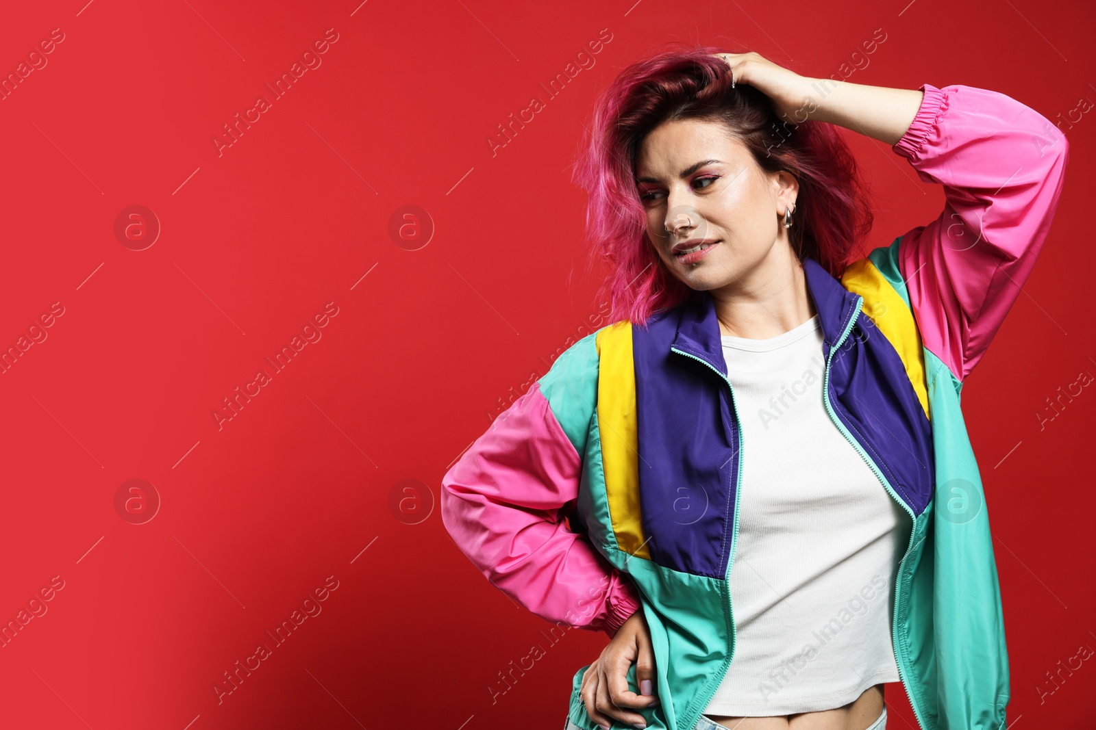 Beautiful woman with pink dyed hair on red background, space for text Photo of Beautiful woman with pink dyed hair on red background, space for text