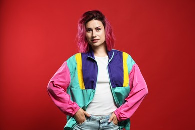 Photo of Beautiful woman with pink dyed hair on red background