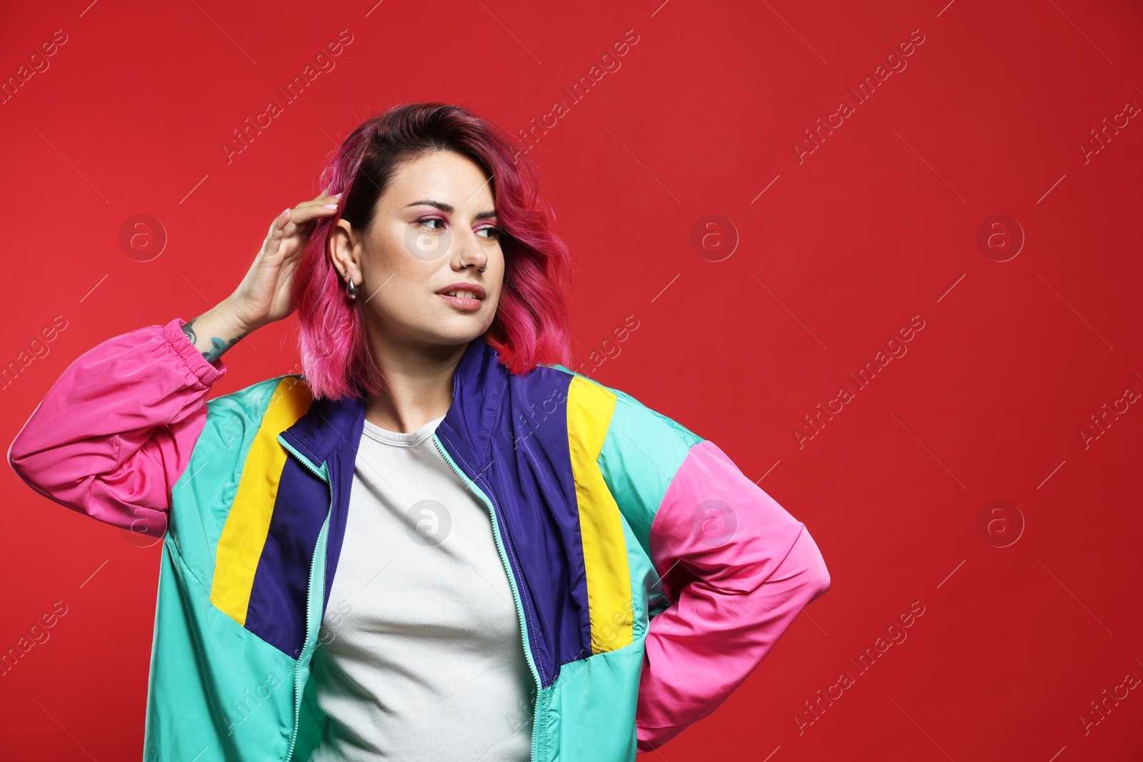 Beautiful woman with pink dyed hair on red background, space for text Photo of Beautiful woman with pink dyed hair on red background, space for text