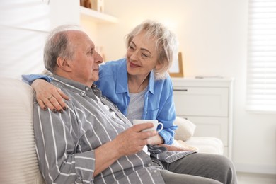 Photo of Lovely senior couple relaxing together on sofa at home