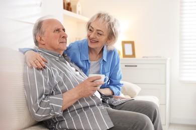 Photo of Lovely senior couple relaxing together on sofa at home