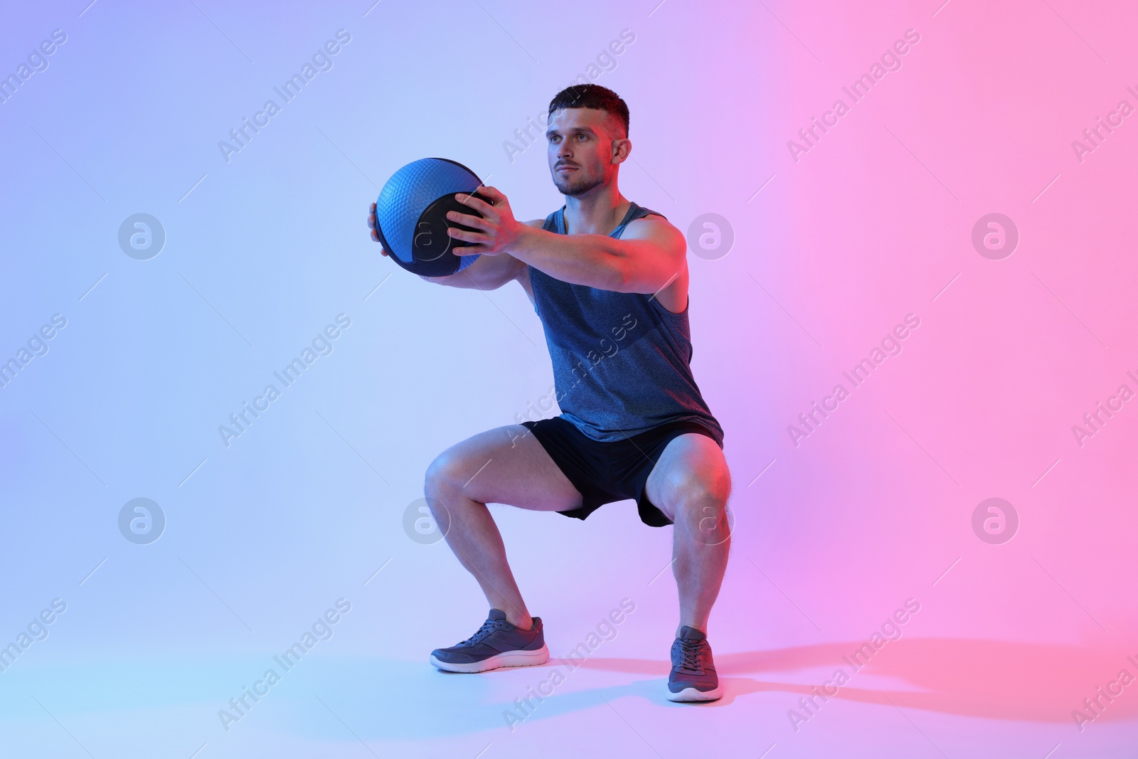 Man exercising with medicine ball on color background Photo of Man exercising with medicine ball on color background